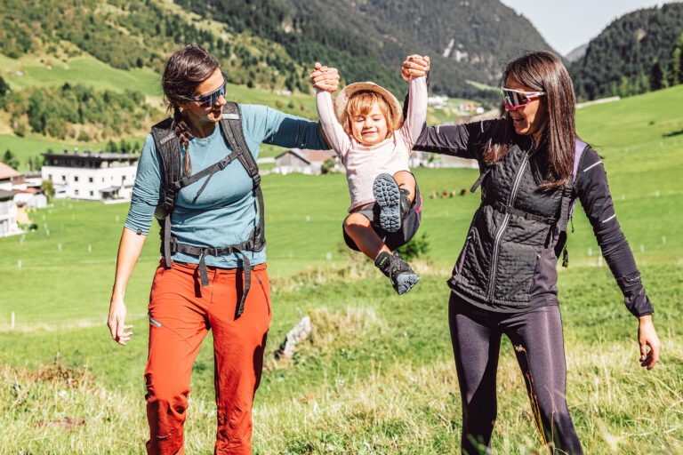 Zwei Frauen und ein Kleinkind wandern im Tal